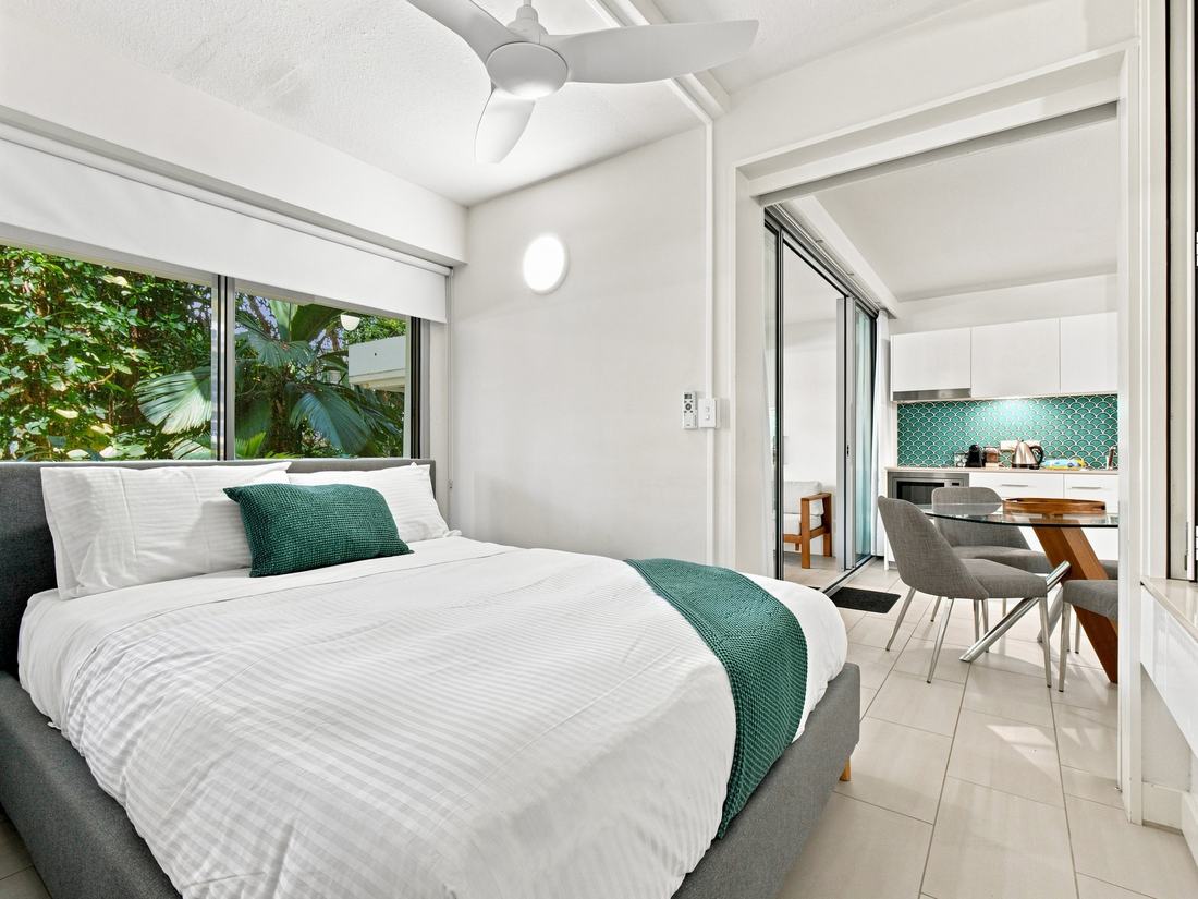 Bedroom with a rainforest window view and teal accents